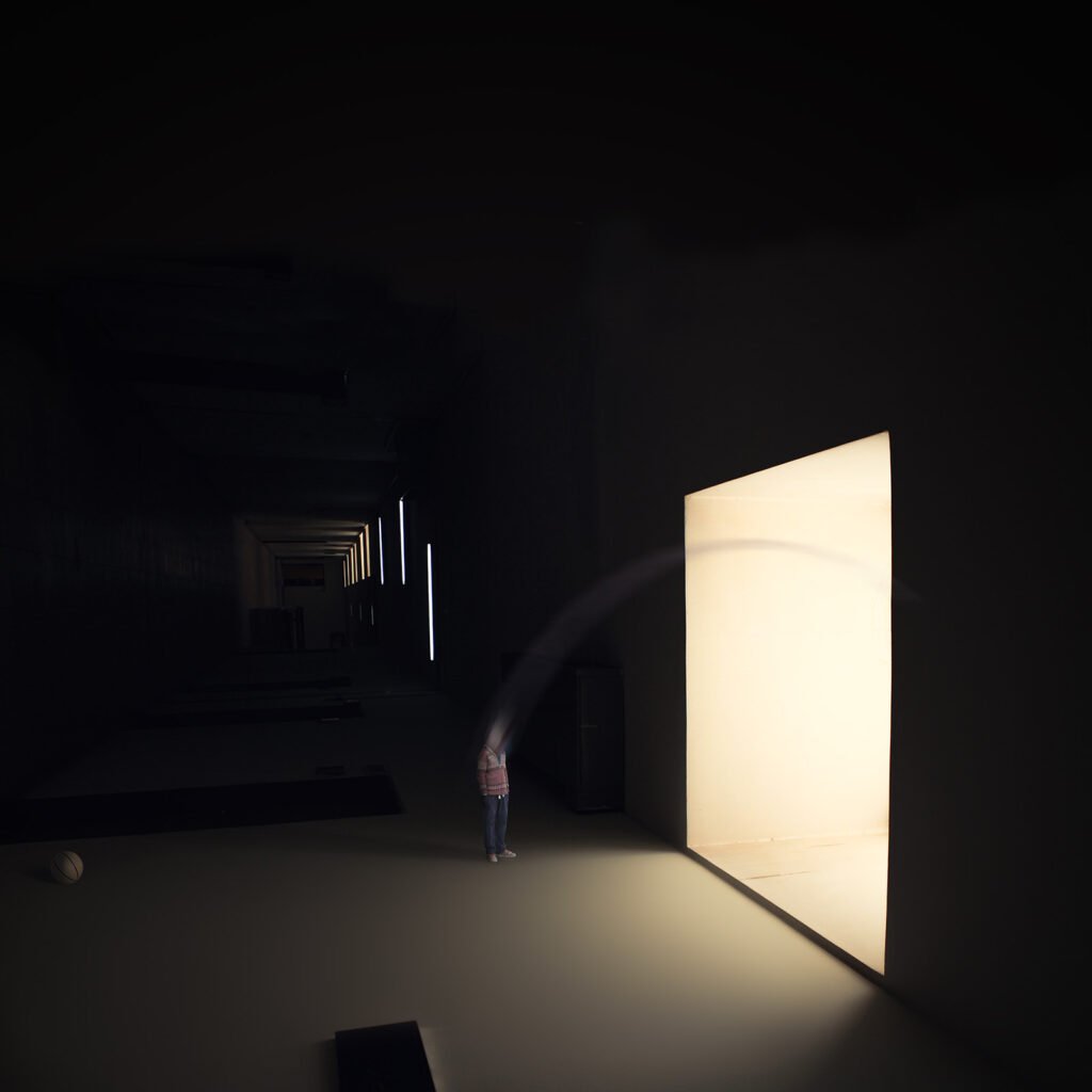 Minimalist fine art photography from the 'Comatose' collection, exploring consciousness through solitary silhouettes, stark shadows, and blinding geometric light.